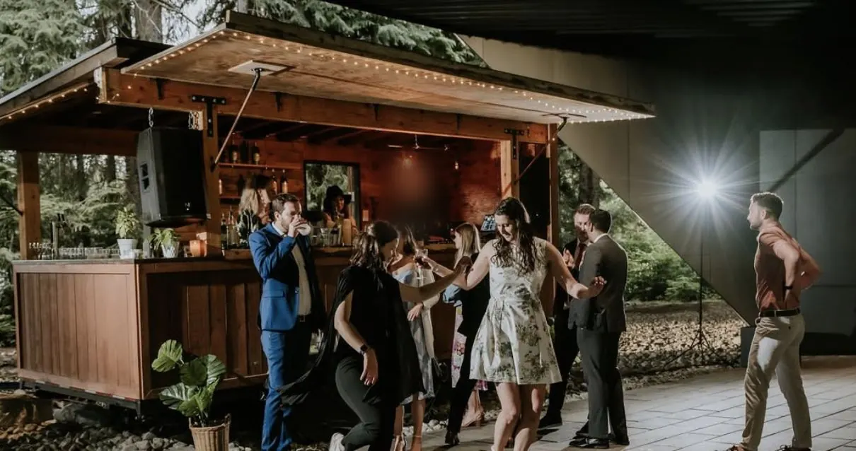 Wedding guests dancing in front of the lit-up Boombox bar at the Audain Art Museum