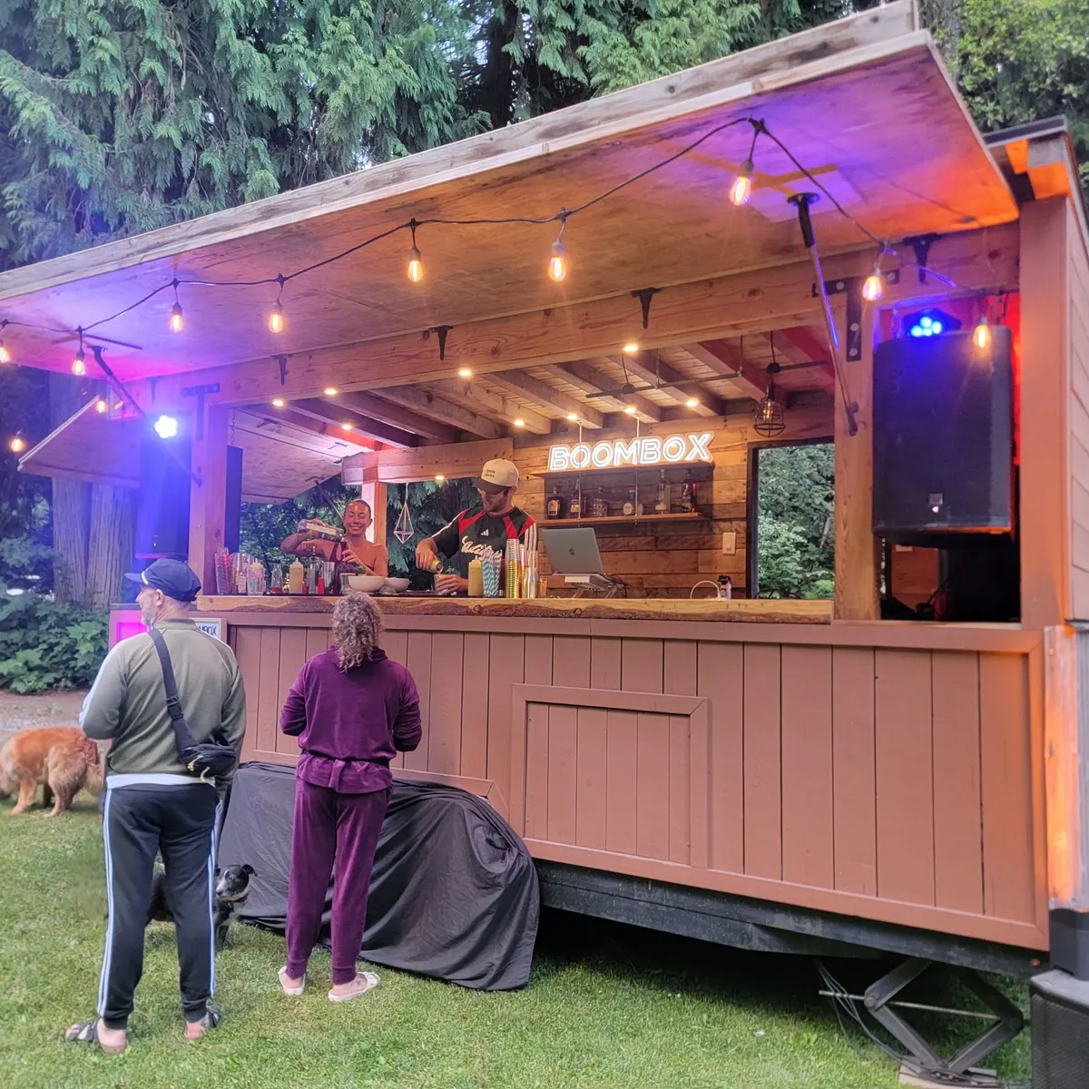 The Whistler Boombox mobile bar lit up for an evening event with its BOOMBOX neon sign